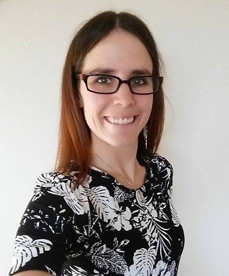 Megan in glasses wearing a floral print top indoors