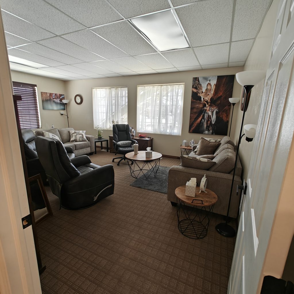 Cozy living room with sofas, armchairs, coffee tables, and bright windows creating a comfortable atmosphere
